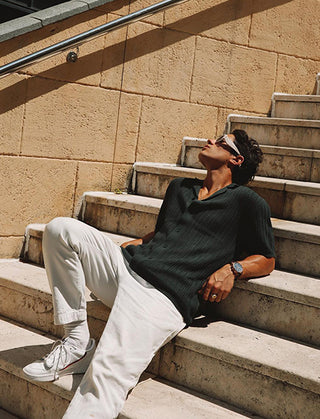 A you male wearing a casual shirt laying on stairs